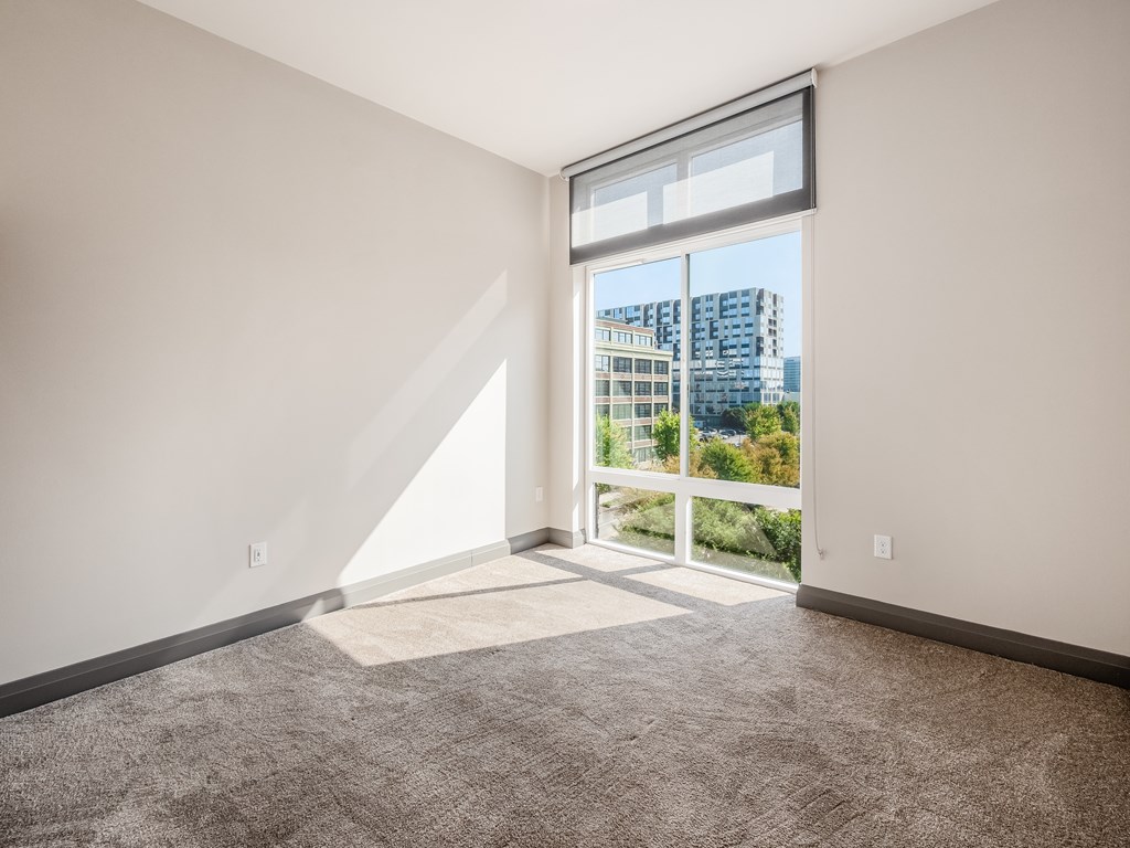 A room with a large window overlooking a cityscape.