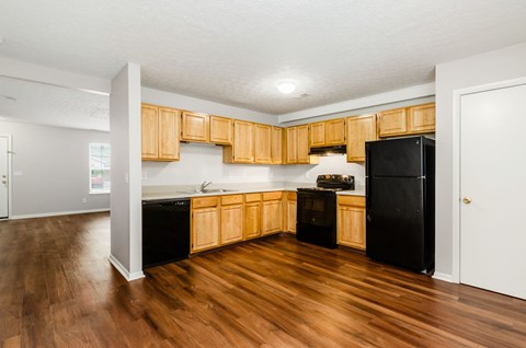 A kitchen with wooden cabinets and black appliances.
