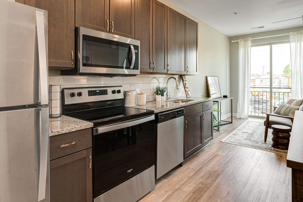 a kitchen with stainless steel appliances and wooden cabinets at Adelphi Quarter, Columbus