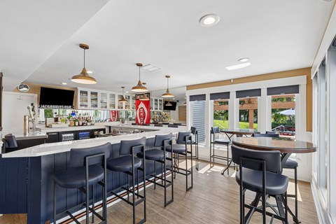 A bar with a counter and chairs is shown.