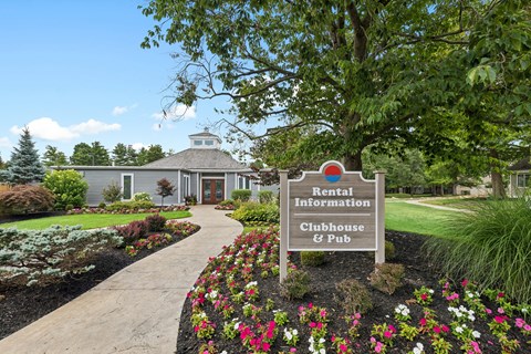 A sign in front of a building that says Rental Information Clubhouse & Pub.