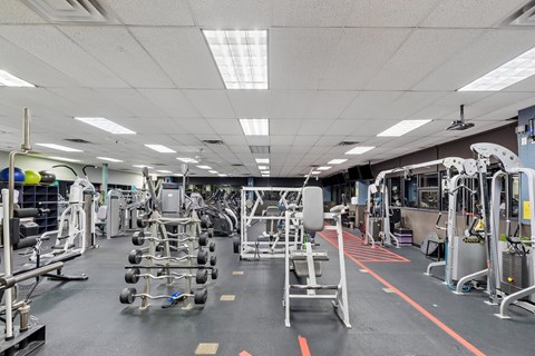 A gym with a variety of equipment including weights and machines.