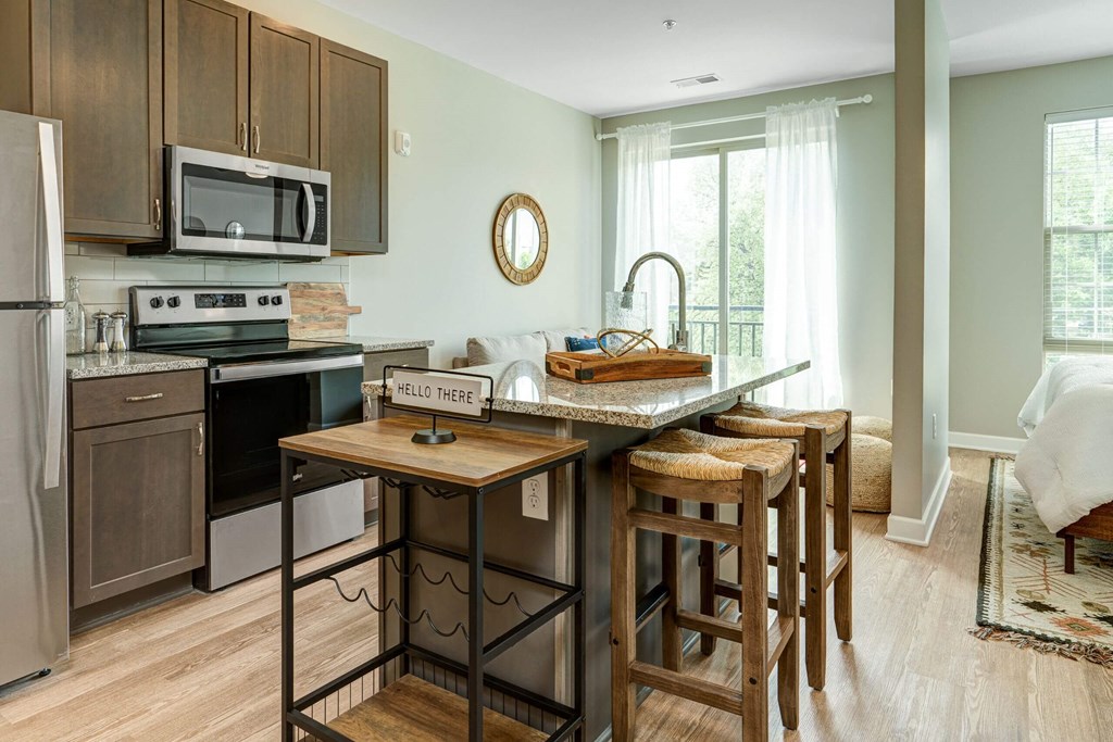 a kitchen with an island with wooden stools at Adelphi Quarter, Columbus