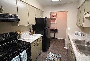 a kitchen with white cabinets and a black refrigerator