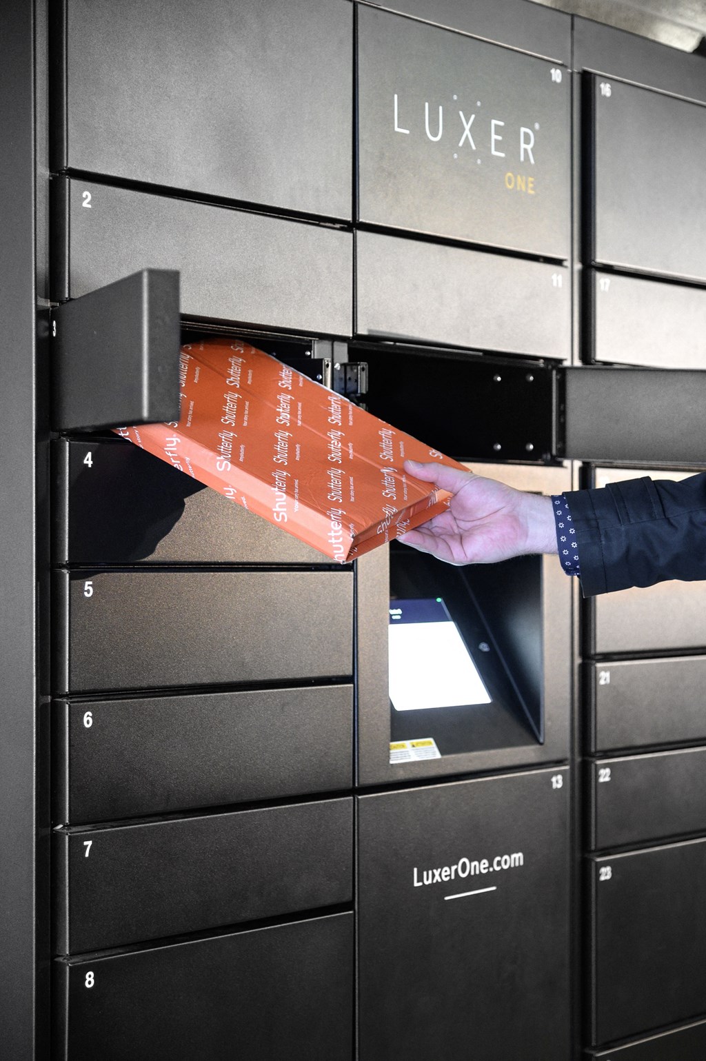 a hand is reaching into a drawer of a luzerne oven