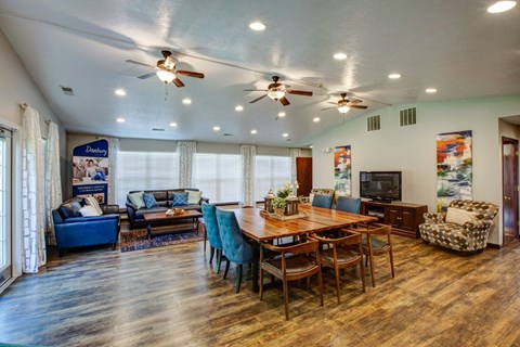 A spacious dining room with a wooden table and chairs.