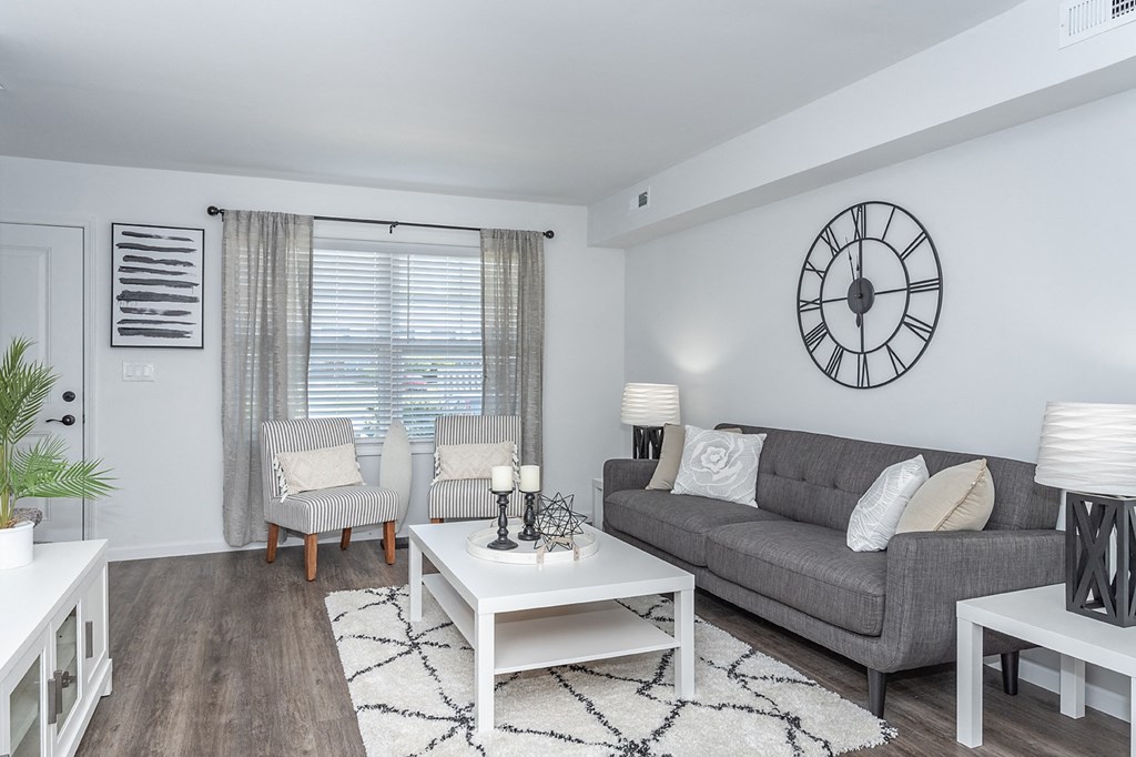 a living room with a couch and a clock on the wall