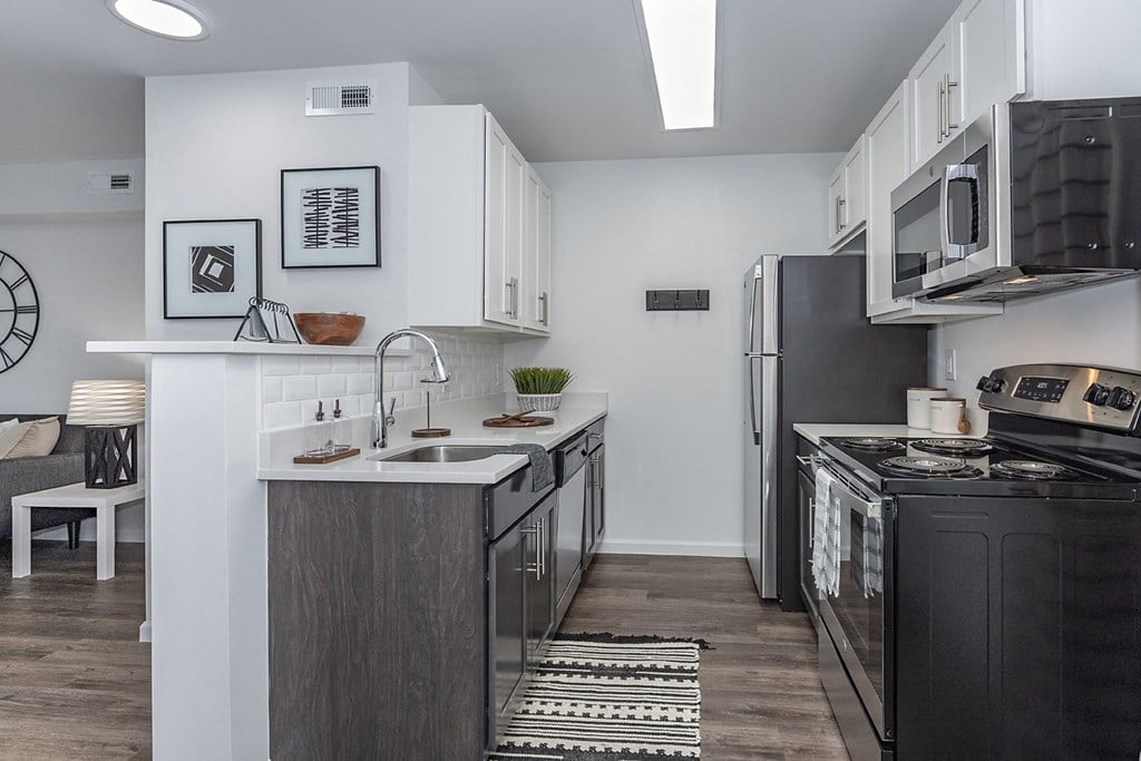 a kitchen with stainless steel appliances and a sink and a refrigerator