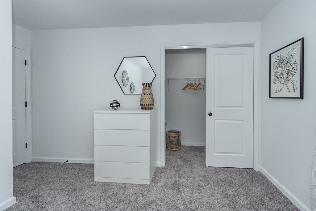 an empty bedroom with a closet and a door to a bathroom