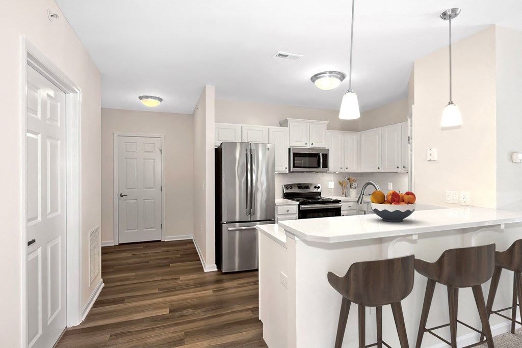 a kitchen with a large island and a stainless steel refrigerator