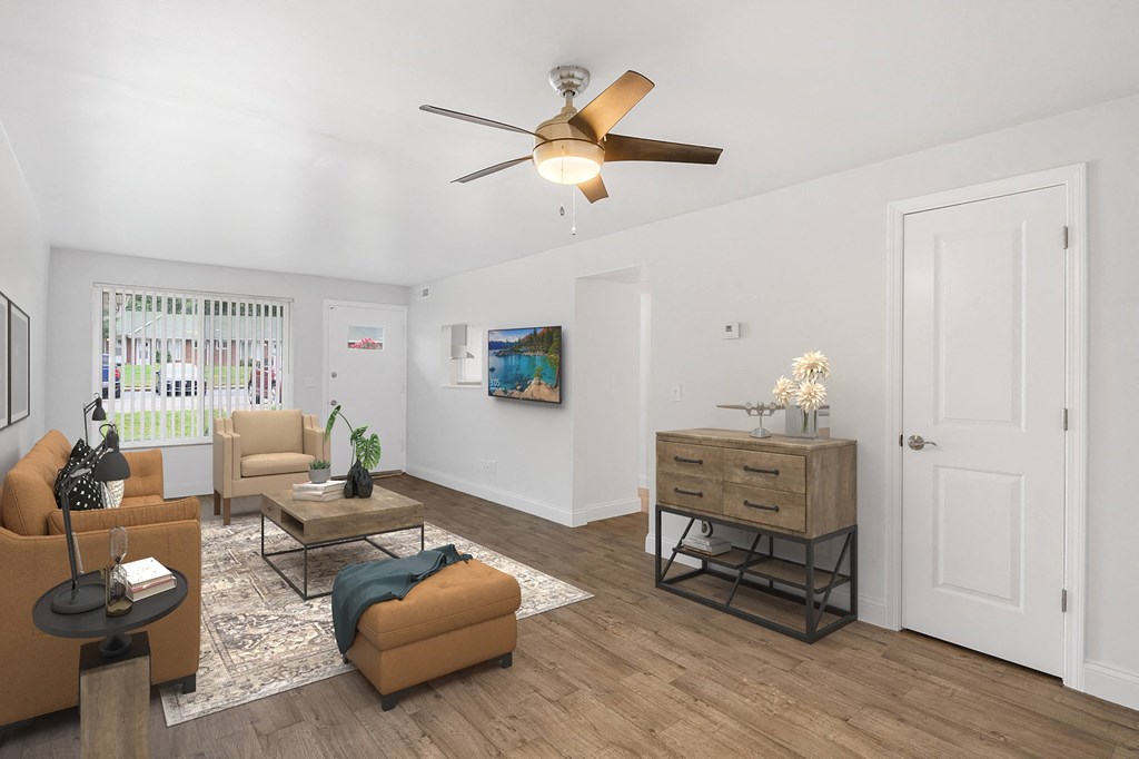 a living room with white walls and a ceiling fan