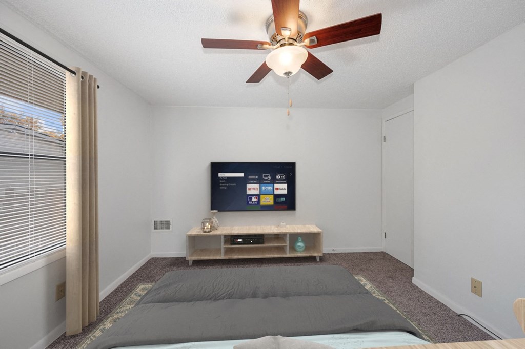 a bedroom with a bed and a ceiling fan