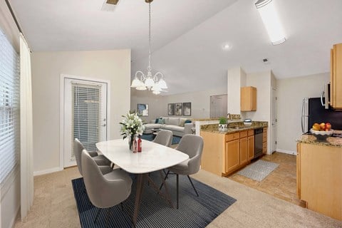 a dining area with a table and chairs and a kitchen in the background at Four Bridges, Liberty Township