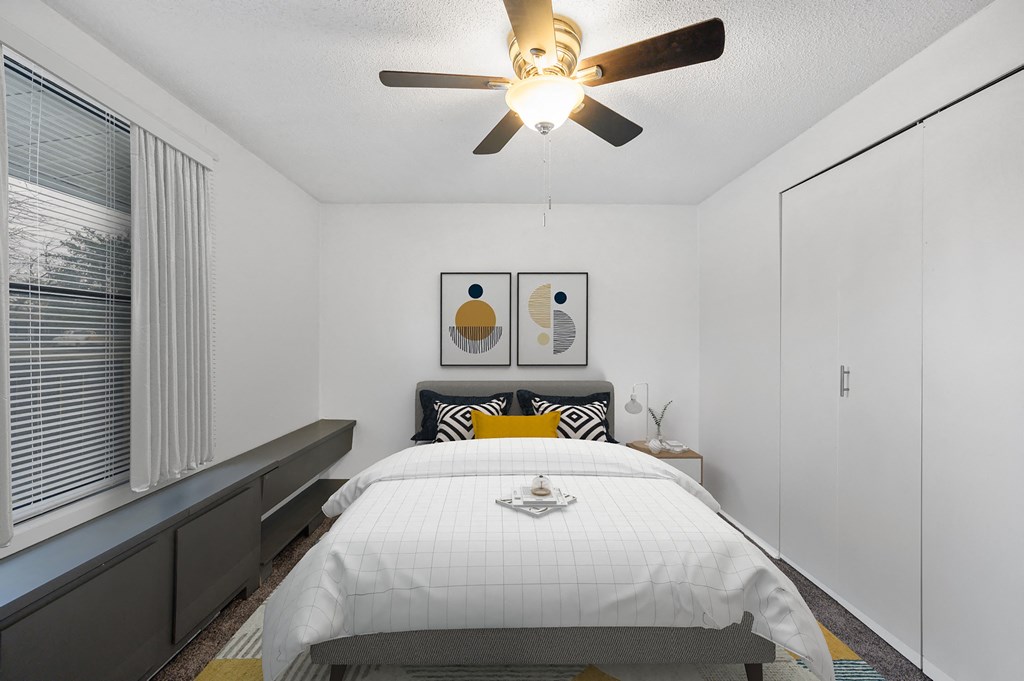 a bedroom with a large bed and a ceiling fan