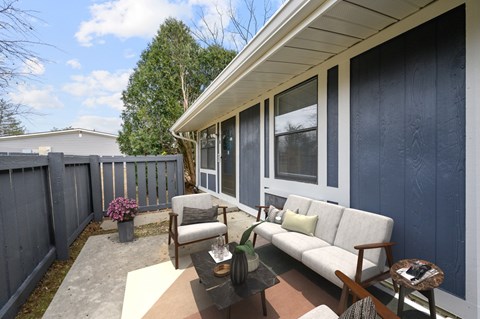 A patio with a couch, chairs, and a coffee table.