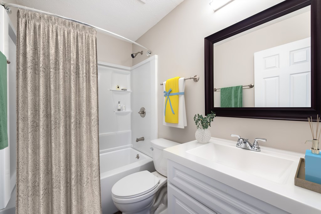 A bathroom with a white toilet, a white sink, and a shower curtain.