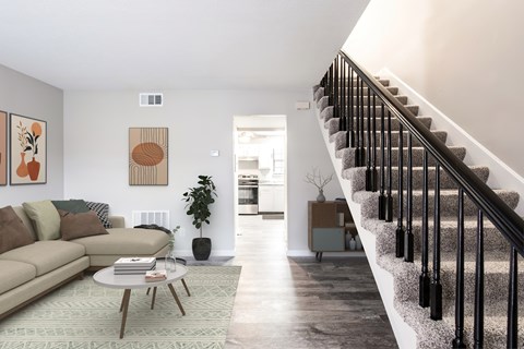 A living room with a staircase leading to the upper floor.