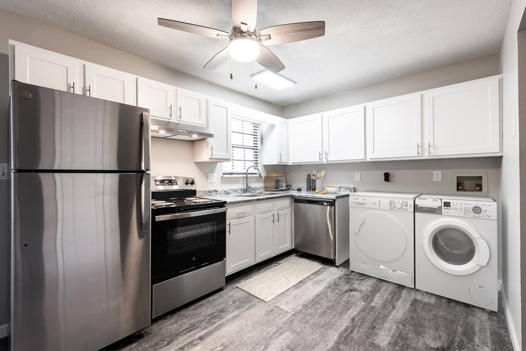 a kitchen with white cabinets and stainless steel appliances