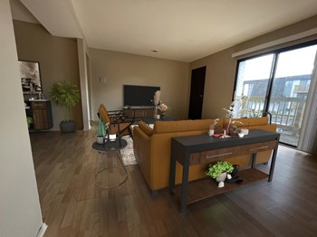 a living room with hardwood floors and a large window - Photo Gallery 5