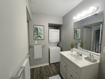 a bathroom with a white sink and a white washer and dryer - Photo Gallery 6