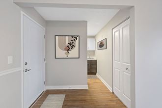 a hallway with white doors and a painting of a bird on the wall