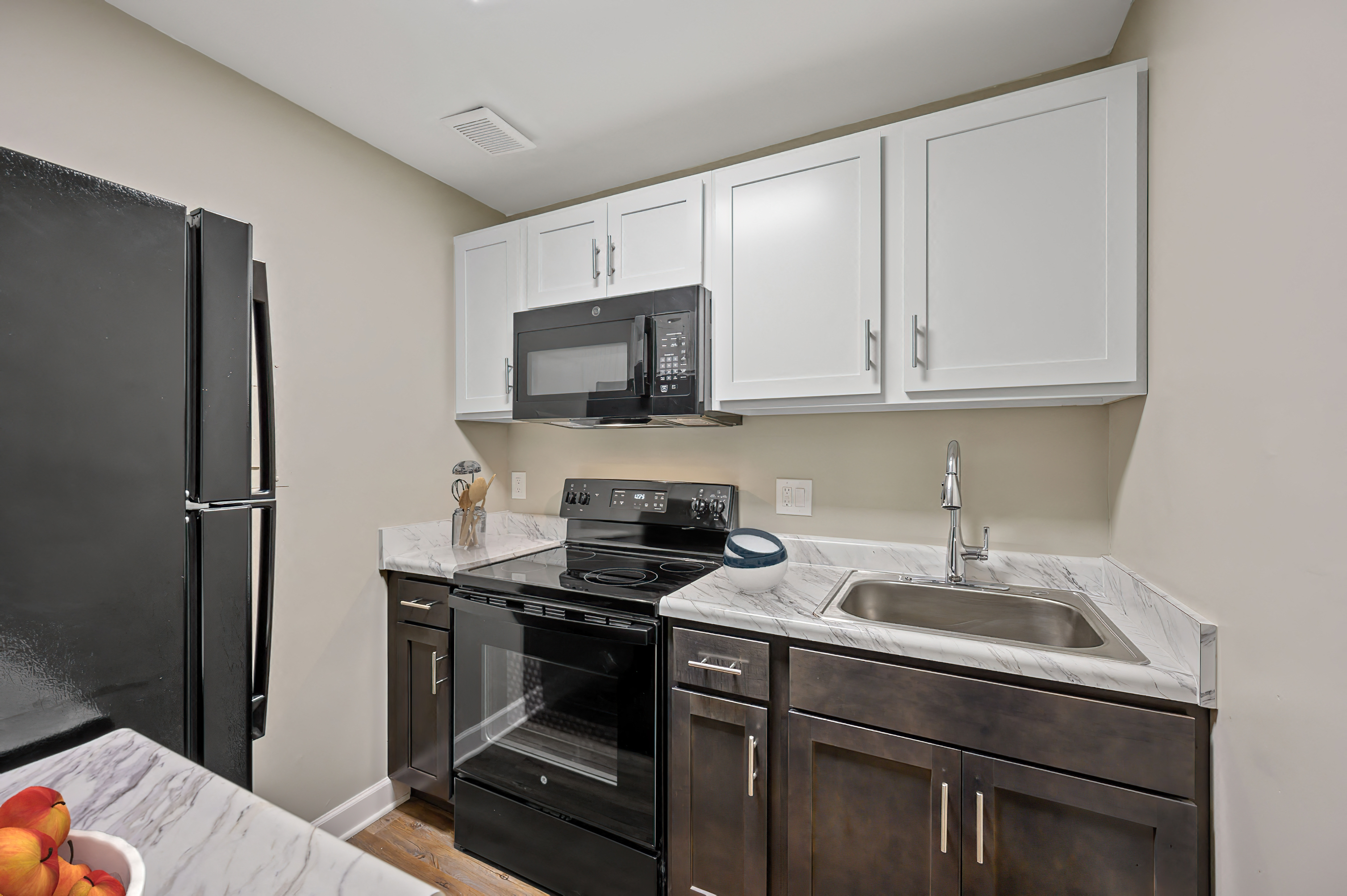 a kitchen with white cabinets and black appliances