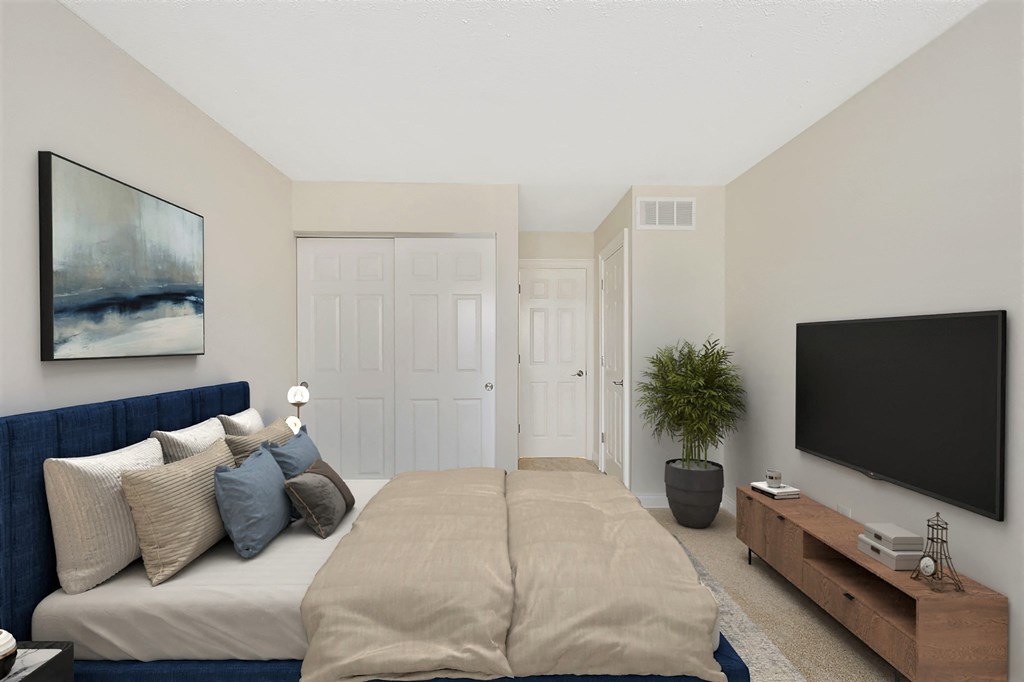 a bedroom with a large bed in front of a tv at Harpers Point Apartments, Ohio