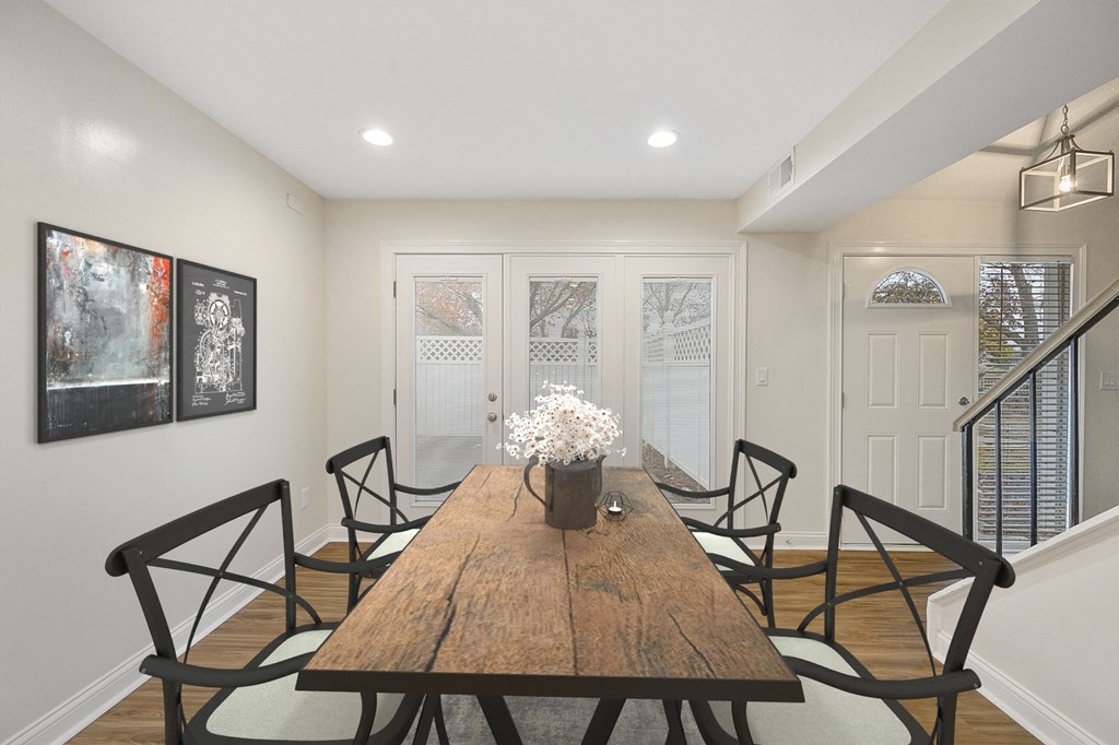 a dining room with a wooden table and black chairs at Harpers Point Apartments, Cincinnati, Ohio