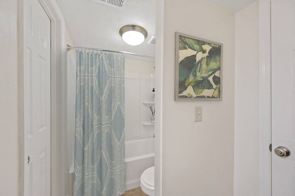 a bathroom with a shower and toilet in a 555 waverly unit at Harpers Point Apartments, Cincinnati, Ohio