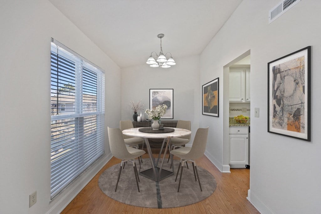 a dining room with a table and chairs and a large window at Harpers Point Apartments, Ohio
