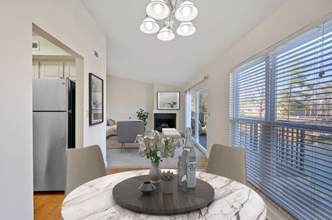 a dining room with a round table with four chairs and a fireplace in the background at Harpers Point Apartments, Cincinnati, OH