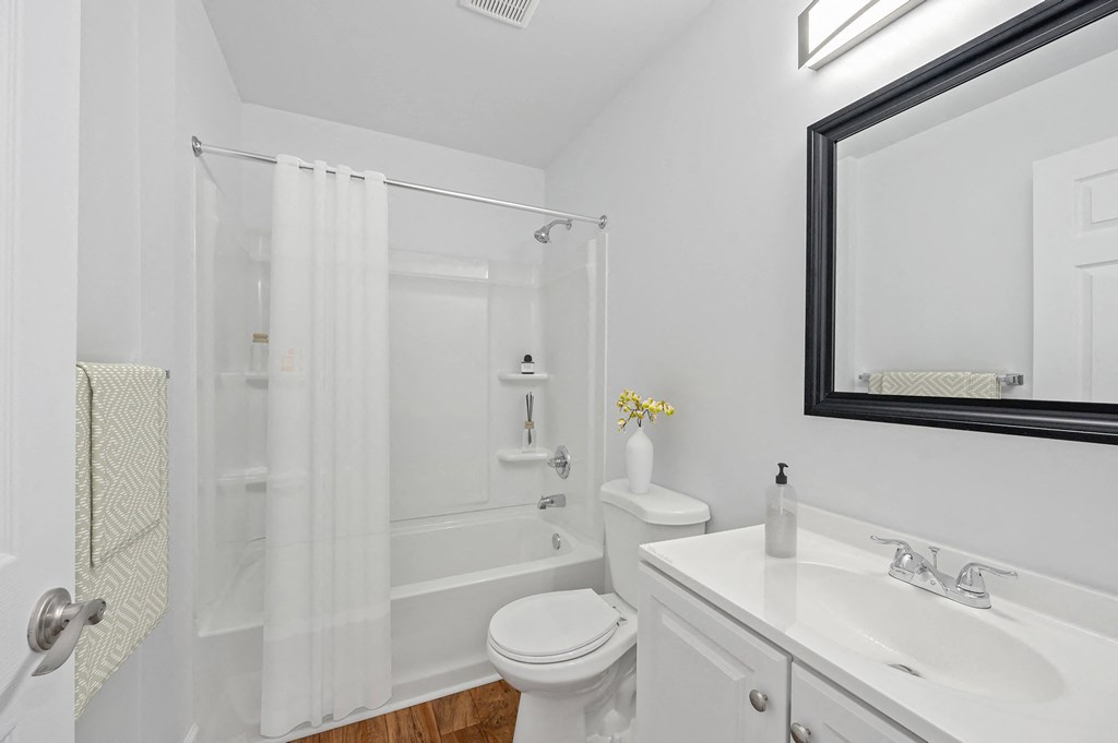 a bathroom with a white sink and toilet next to a white bathtub with a shower curtain