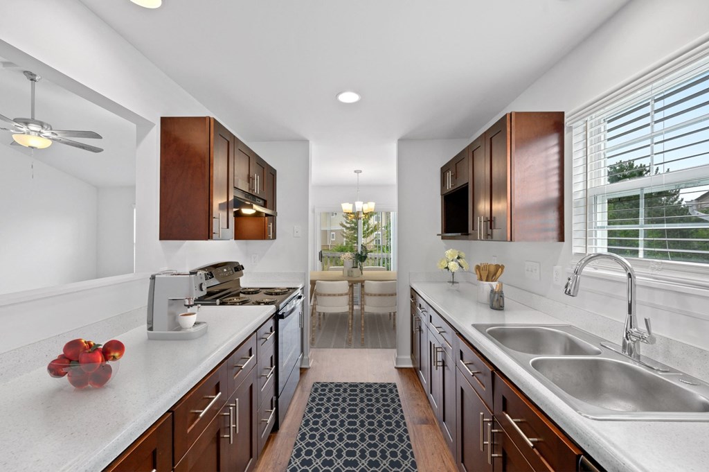 a kitchen with white countertops and dark wood cabinets