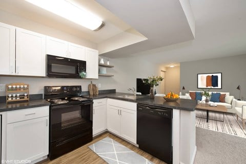 a kitchen with white cabinetry and black countertops