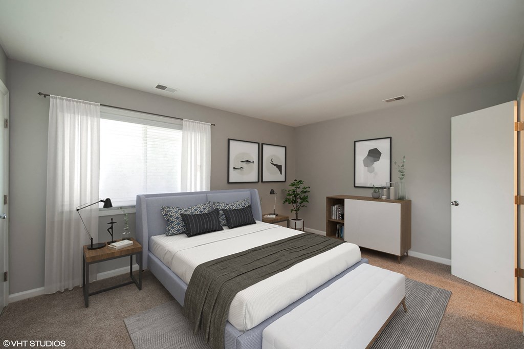 a bedroom with a bed and a dresser in a 555 waverly unit