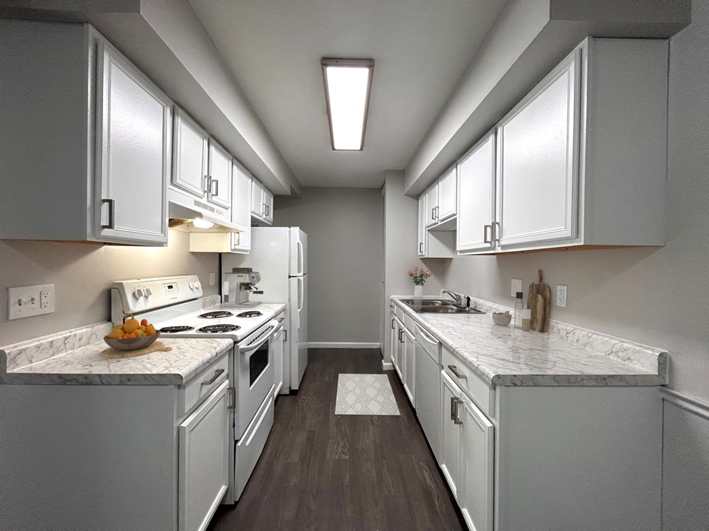 a kitchen with white appliances and marble counter tops