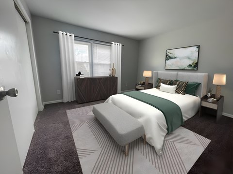 a bedroom with gray walls and a white bed with a green blanket