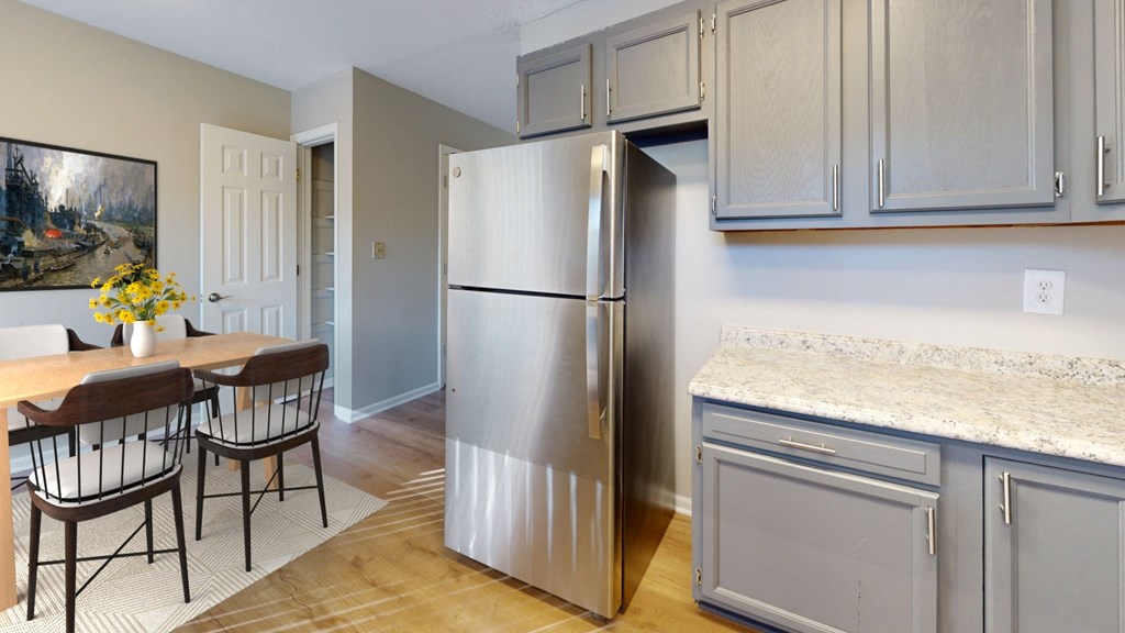 a kitchen with a stainless steel refrigerator and a table and chairs