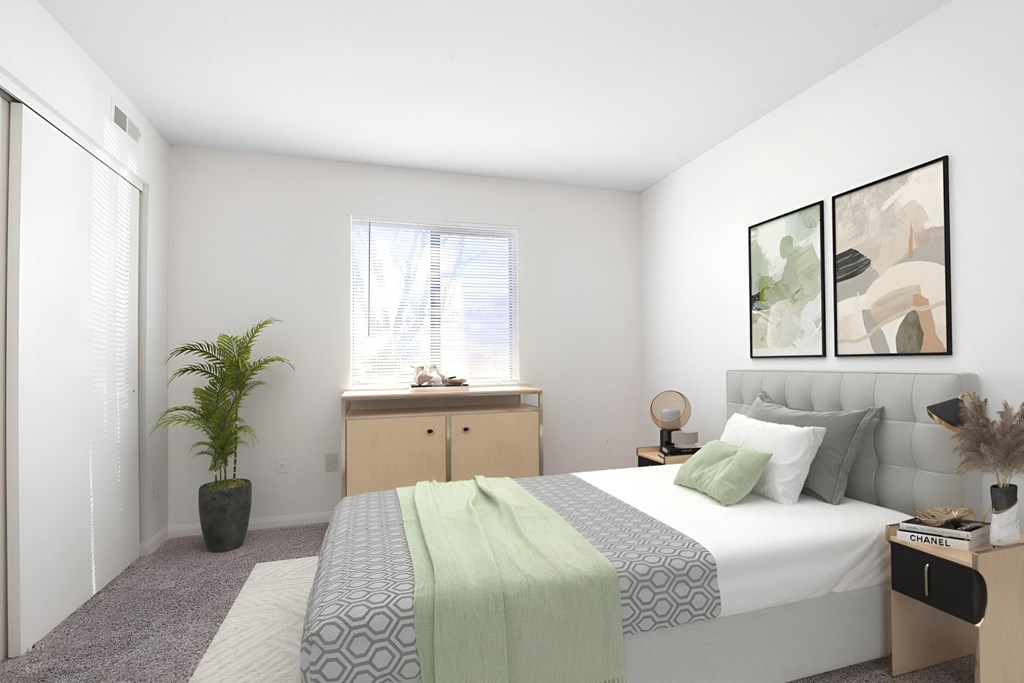 A bedroom with a bed, nightstand, and a plant.