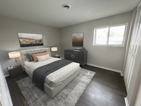 A bedroom with a large bed, a nightstand, and a painting on the wall.