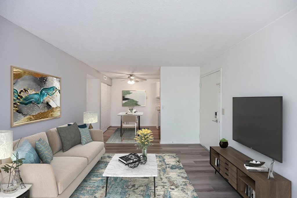 A living room with a couch, a coffee table, and a painting on the wall.
