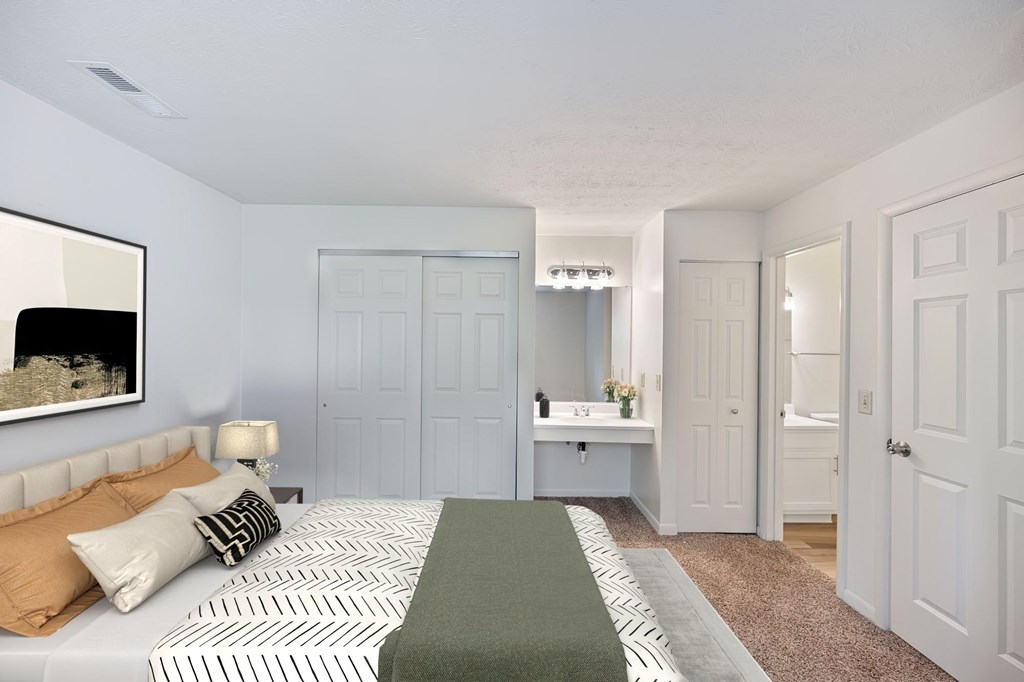 A bedroom with a bed, a nightstand, and a mirror.