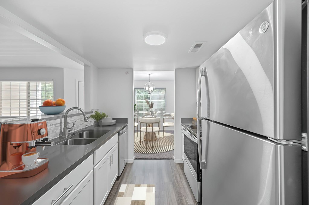 A modern kitchen with a large refrigerator and stainless steel appliances.