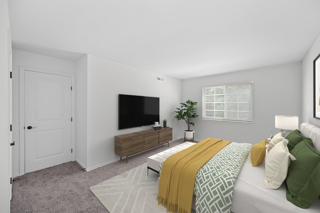A bedroom with a bed, a television, and a window with blinds.