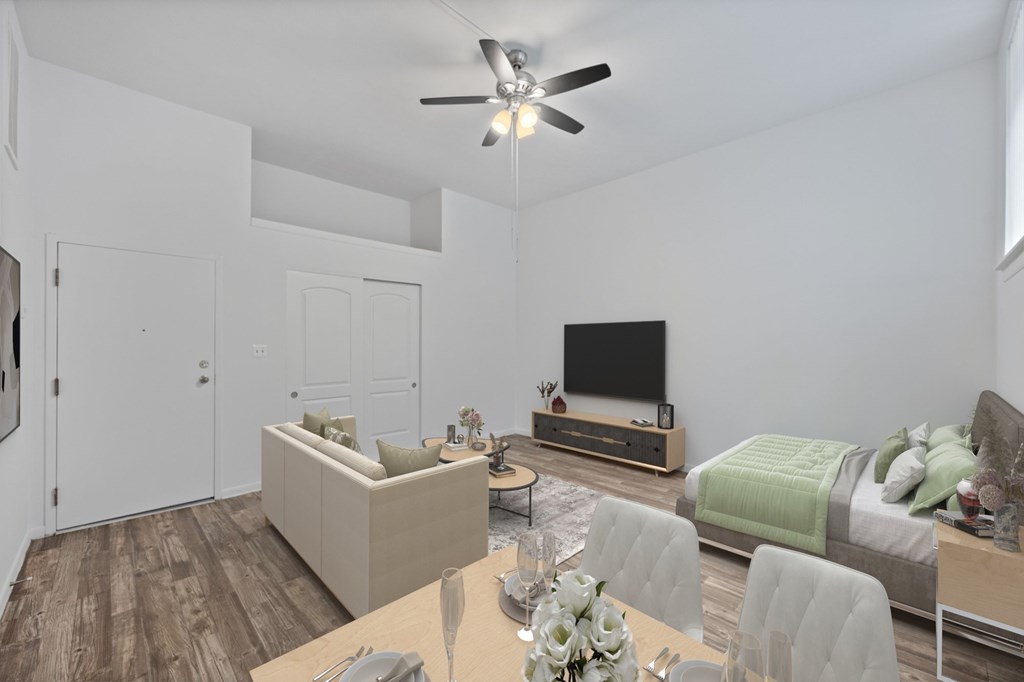 A modern living room with a television, couch, and dining table.