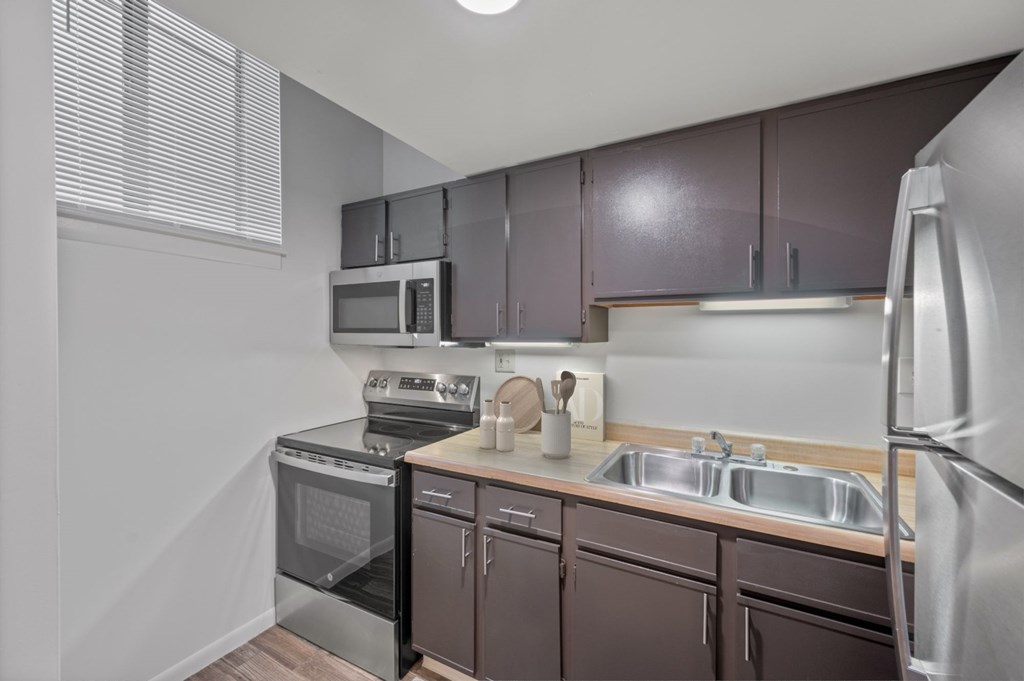 A kitchen with brown cabinets and stainless steel appliances.