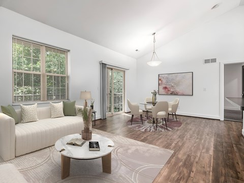 A living room with a white sofa, a coffee table, and a painting on the wall.