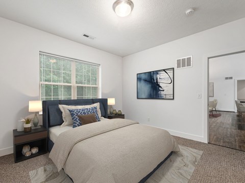 A bedroom with a large bed and a painting on the wall. at River View at Bexley Apartments, River View at Bexley, OH