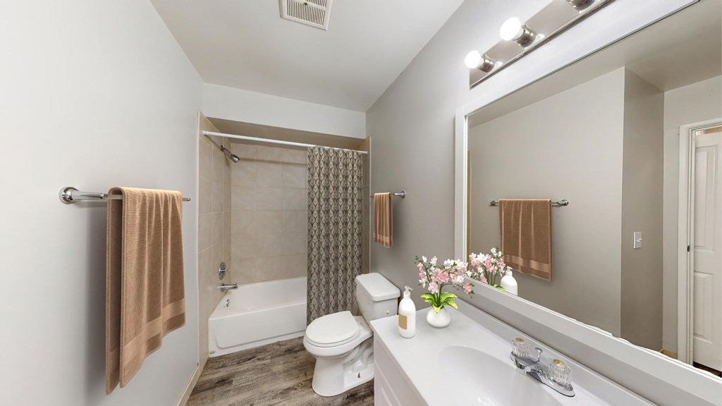 A bathroom with a toilet, sink, and shower.