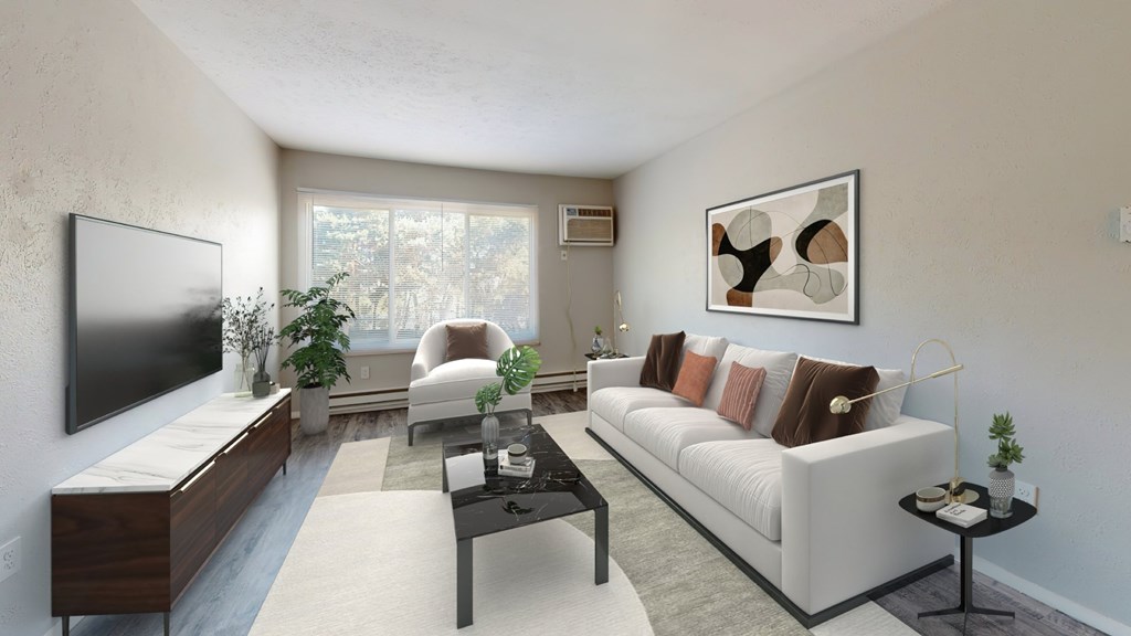 A living room with a white couch, a television, and a coffee table.